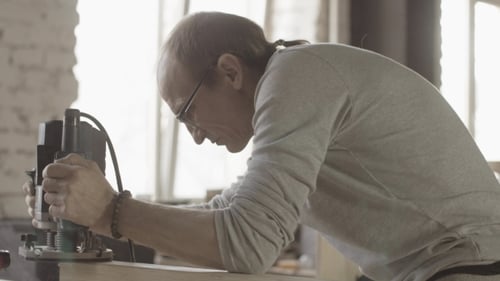 Man Using a Router in Woodworking Workshop