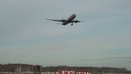 Commercial Airplane Flying Over on Cloudy Day