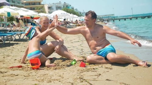 Family Of Three Giving Hi-fives On The Beach