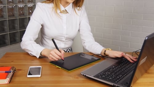 Young Woman Works on Graphic Tablet and Laptop
