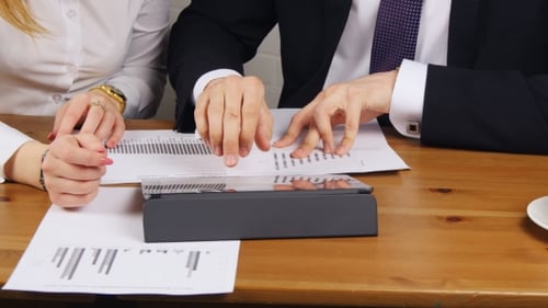 Business Professionals Analyzing Data on Tablet in Office