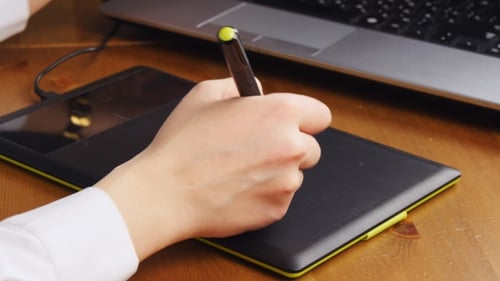 Hand Using Stylus on Digital Drawing Tablet