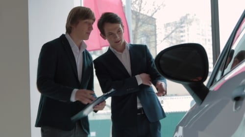 Salesman Assisting Client In a Car Dealership