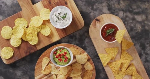Vista de cerca de una variedad de patatas fritas y salsas en bandejas de madera sobre superficie negra