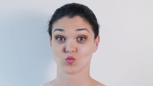 Junge Frau verzieht sich, blinzelt und hat Spaß