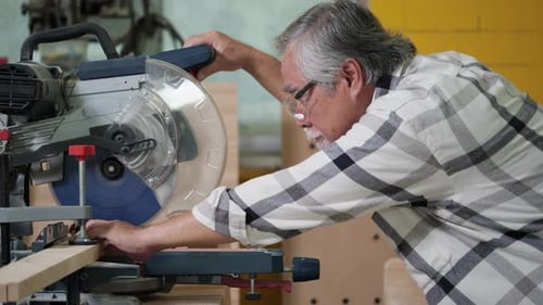 Senior Adult Cutting Wood with a Chop Saw