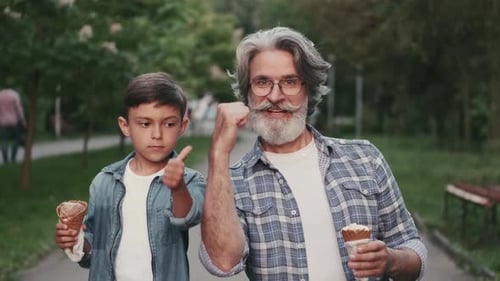 Grandfather and Grandson Eat Ice Cream in Park