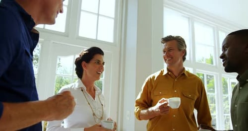 Adults Talking and Drinking Coffee in Bright Room