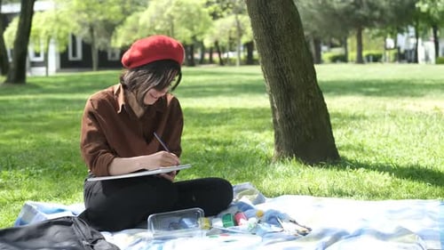 Young Adult Drawing in Park on Sunny Day