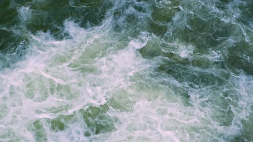 Luftaufnahme des Flusswasserfalls mit klarem türkisfarbenem Wasser, das mit dickem weißem Schaum herunterfällt.