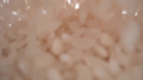 Rice Grains Pouring in a Pile on White Background