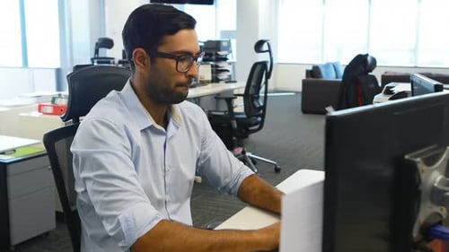 Man Typing at Desk in Modern Office