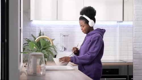 Woman Listens to Music While Mixing Ingredients