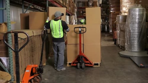 Delivery man moving packages in warehouse
