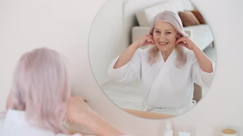 Senior Woman Smiling in Bathroom Mirror