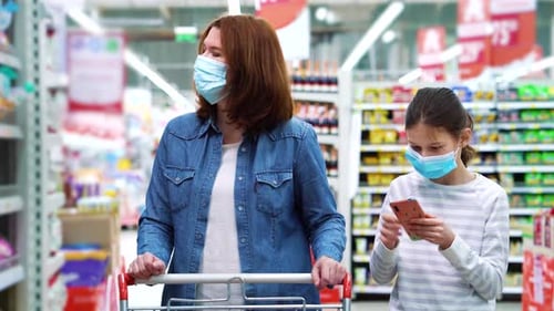 Mãe e filha fazendo compras no supermercado durante a pandemia