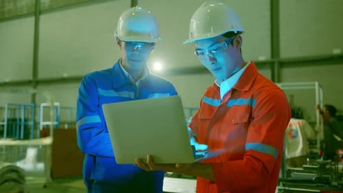 engineer standing hand use laptop application result report discuss cnc machine operate