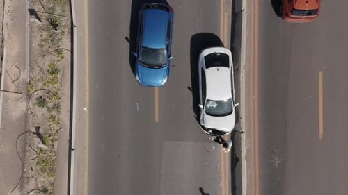 Car crash on a busy highway with smashed car and traffic passing by.