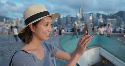 Woman use of mobile phone to take photo in city of Hong Kong