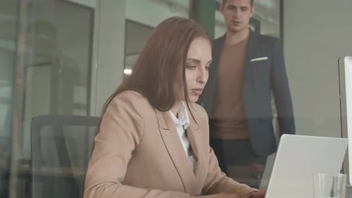 Woman Working at Computer with Colleague in Office