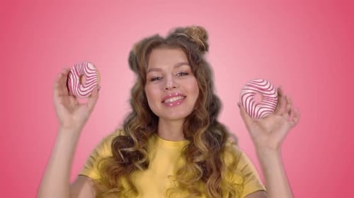 Woman with Doughnuts in front of Pink Screen