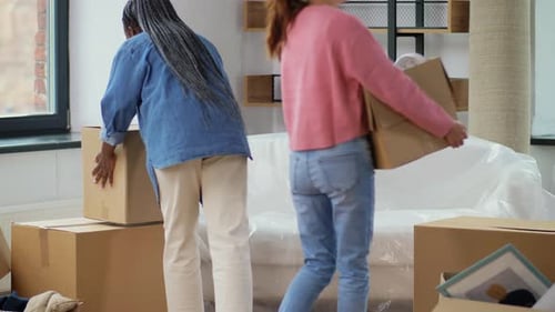Women moving into new apartment with boxes