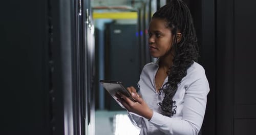 Woman Uses Tablet in Dark Server Room