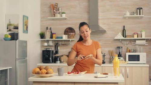 Woman Dancing While Making Sandwich in Kitchen