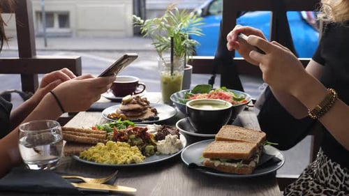 Healthy Hipster Lunch in the City. Two Food Blogger Friends Taking Pictures of Their Food with