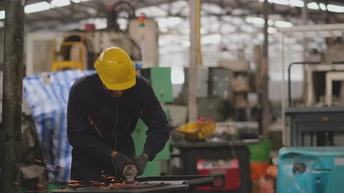 Techniker mit dunkelblauer Uniform verwenden eine Polier- oder Schweißmaschine an der Stahlplatte