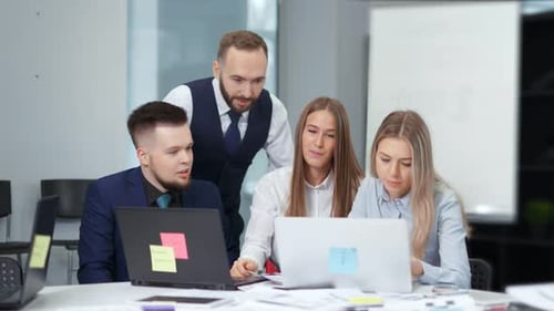 Group of Business People Discussing Working at Modern Office Looking and Pointing at Screen Laptop