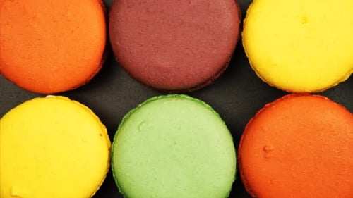 Vue de dessus d'une rangée de macarons colorés sur une table noire