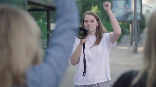 Young Woman Speaks into Megaphone at Protest