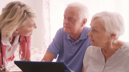 Friendly Nurse Visiting Senior Couple at Home