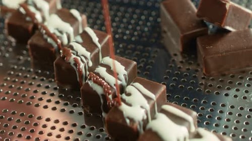 Delicious Candies Covering with Chocolate and Icing Pour Caramel.