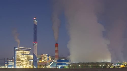 Industrial Complex Emitting Smoke at Sunrise