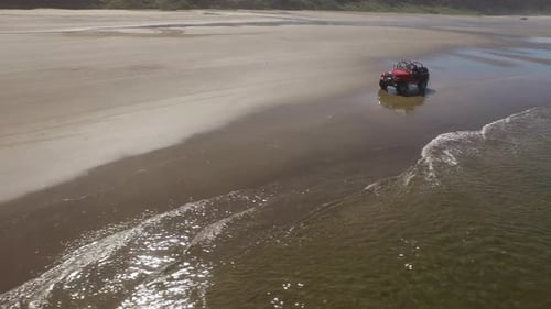 Aerial shot of 4x4 off road vehicle driving on beach