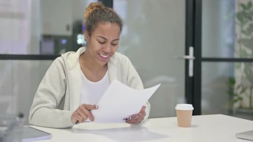 Young Woman Reviews Document in Modern Office