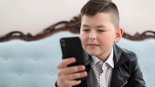 Smiling Boy Looking at a Mobile Phone