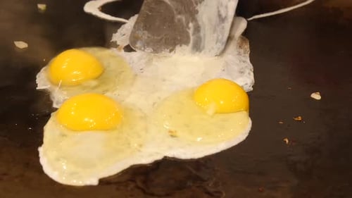 Bright Yolk Eggs Cooking on Griddle Top