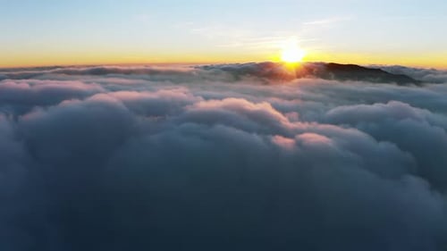 Dicke weiße Wolkenschicht über den Bergen bei Sonnenaufgang