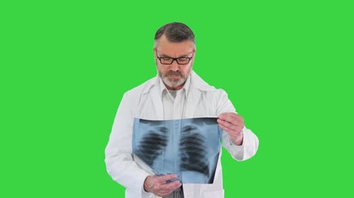 Médecin professionnel vérifiant la radiographie d'un patient en marchant sur une touche chromatique à écran vert