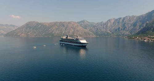 cruise liner with helipad from drone with mountains on background