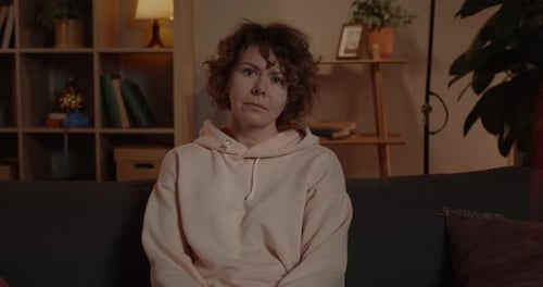 Woman in Hoodie Sitting on Couch Indoors