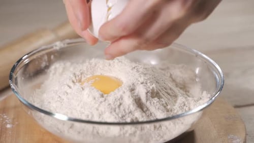 Egg Cracked into Flour for Baking Preparation