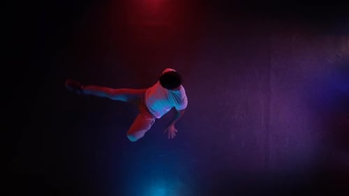 Young Man Dancing Breakdance in Black Studio. Top View. Slow Motion.