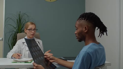 Doctor Explains Medical Scan to Patient in Office