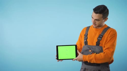 Green Screen Tablet in Mans Hand with Copy Space Isolated on Blue Background