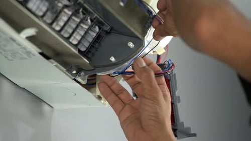 Adult Repairing Air Conditioner Wiring at Home