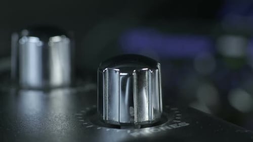 Bouton d'interface audio argenté tournant les doigts féminins